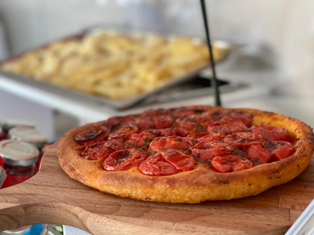 a pepperoni pizza sitting on top of a wooden board at JR Hotels Bari Grande Albergo delle Nazioni in Bari