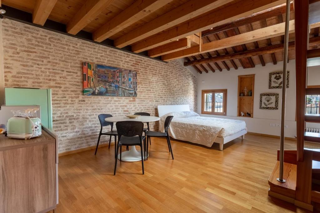 um quarto com uma cama, uma mesa e cadeiras em Loft Mirano Uno (Alloggi alla Campana) em Mirano