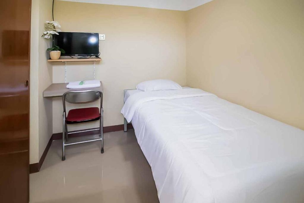 雅加達的住宿－Miana Ancol Residence Mitra RedDoorz，一间卧室配有一张床和一张书桌及电视