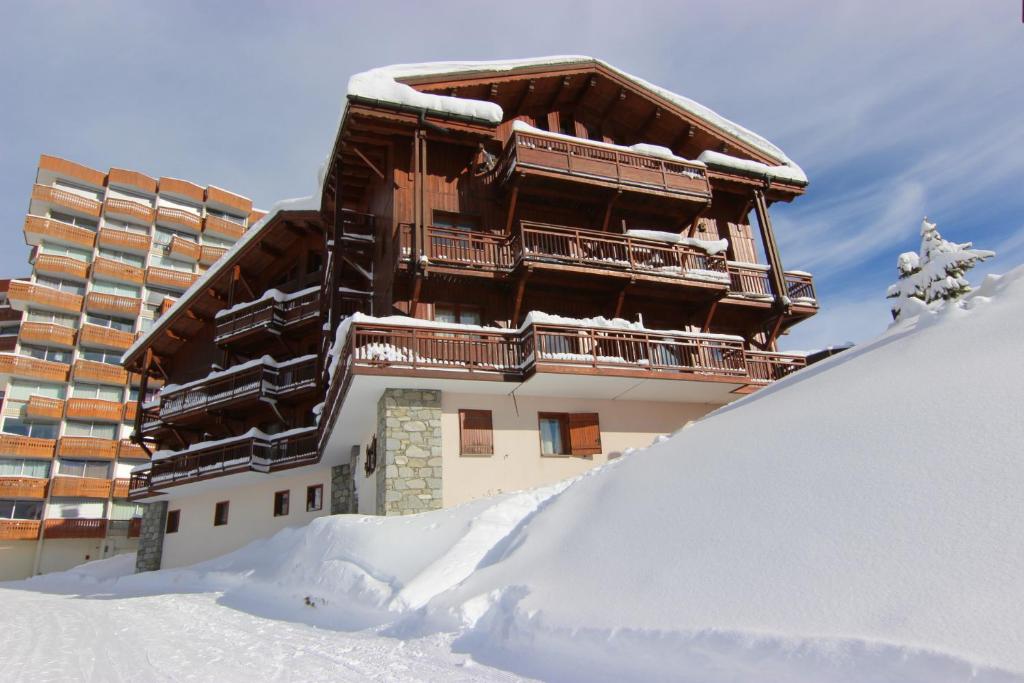 een gebouw bovenop een met sneeuw bedekte helling bij Cristallo Appartements VTI in Val Thorens