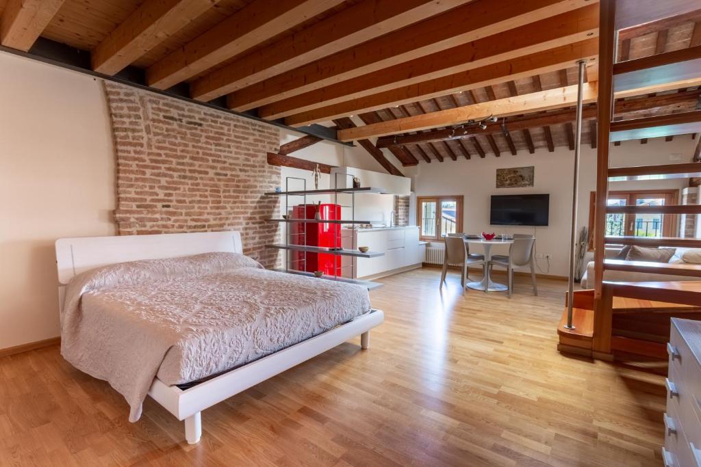 een slaapkamer met een bed en een bakstenen muur bij Loft Mirano Tre (Alloggi alla Campana) in Mirano