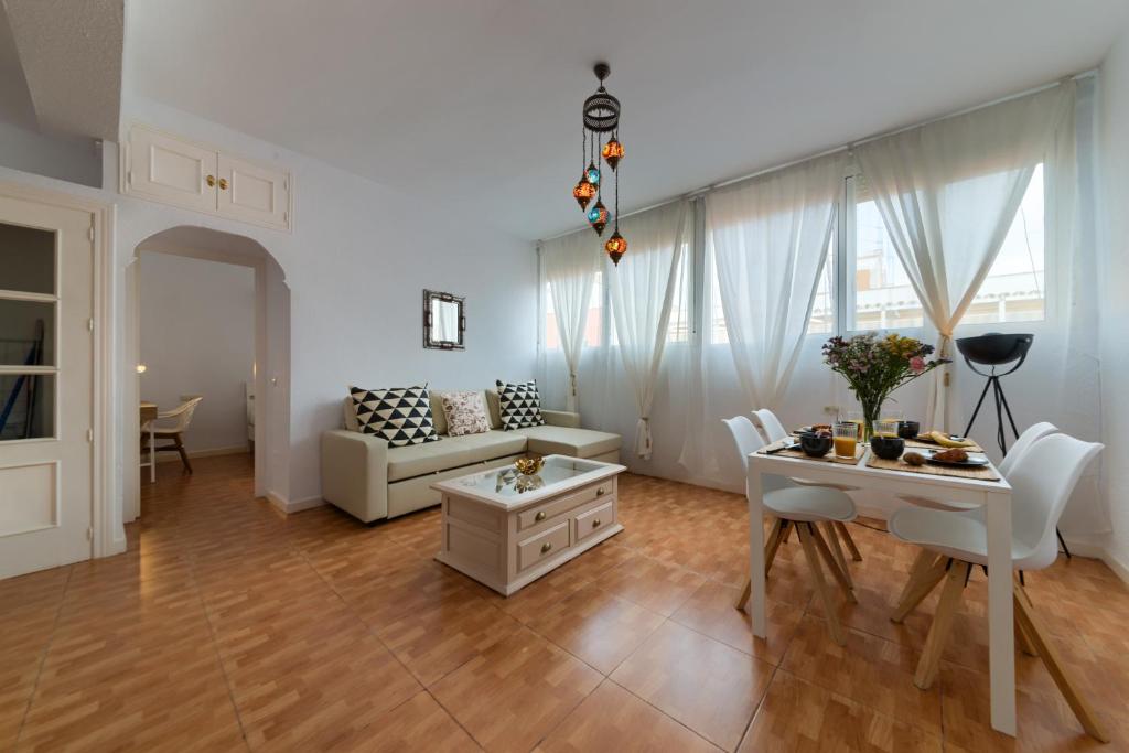 ein Wohnzimmer mit einem Sofa und einem Tisch in der Unterkunft Holidays2Malaga Soho Pasaje de Valencia in Málaga