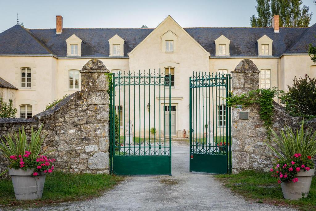 an entrance to a castle with a green gate at Manoir de Bel Ébat in Crossac