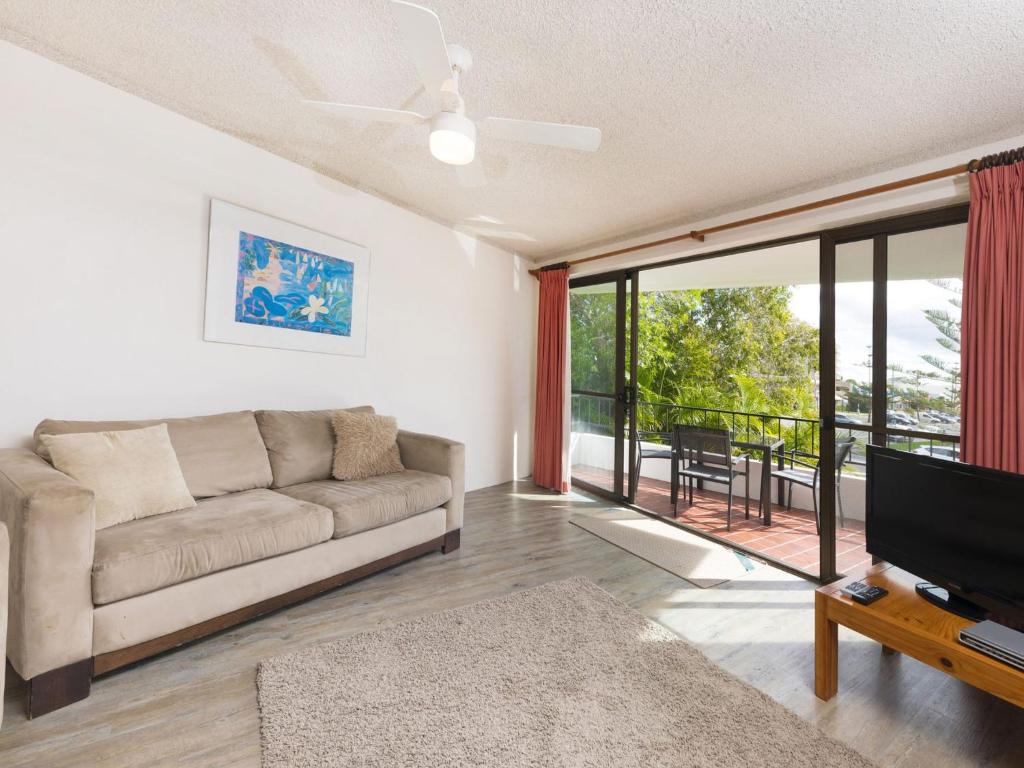 a living room with a couch and a flat screen tv at Centrepoint 10 in Forster