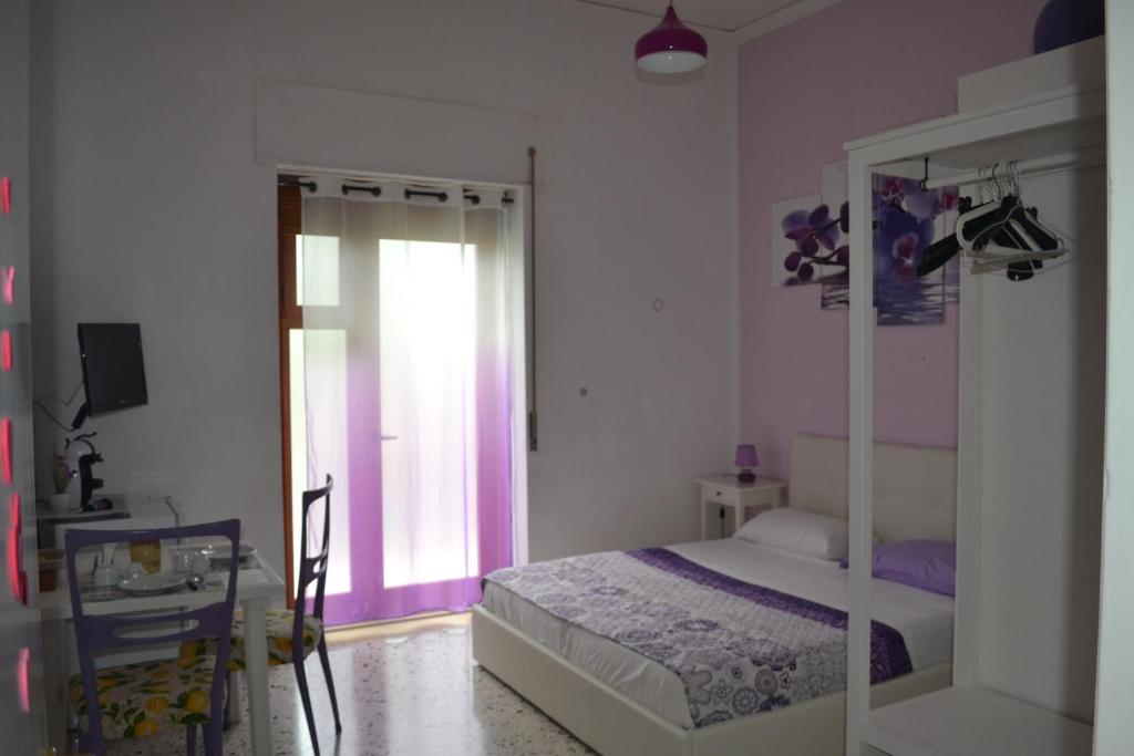 Schlafzimmer mit einem Bett und einer Glasschiebetür in der Unterkunft Sorrento Experience in Sorrent
