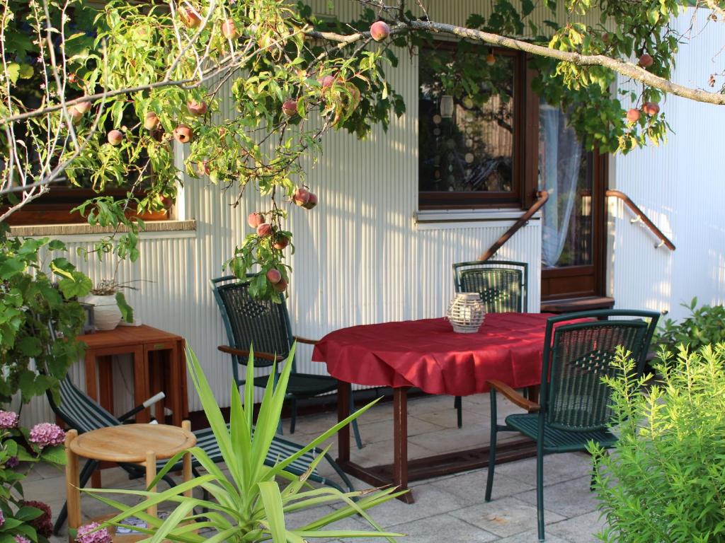 a patio with a red table and chairs at Ferienwohnung Bienenherz in Engelsbrand