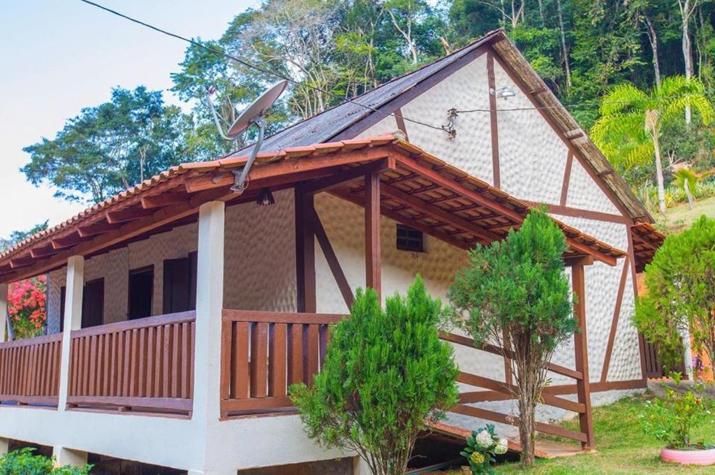 une petite maison avec un toit en gambrel dans l'établissement Sítio e Pousada Vista Verde, à Domingos Martins
