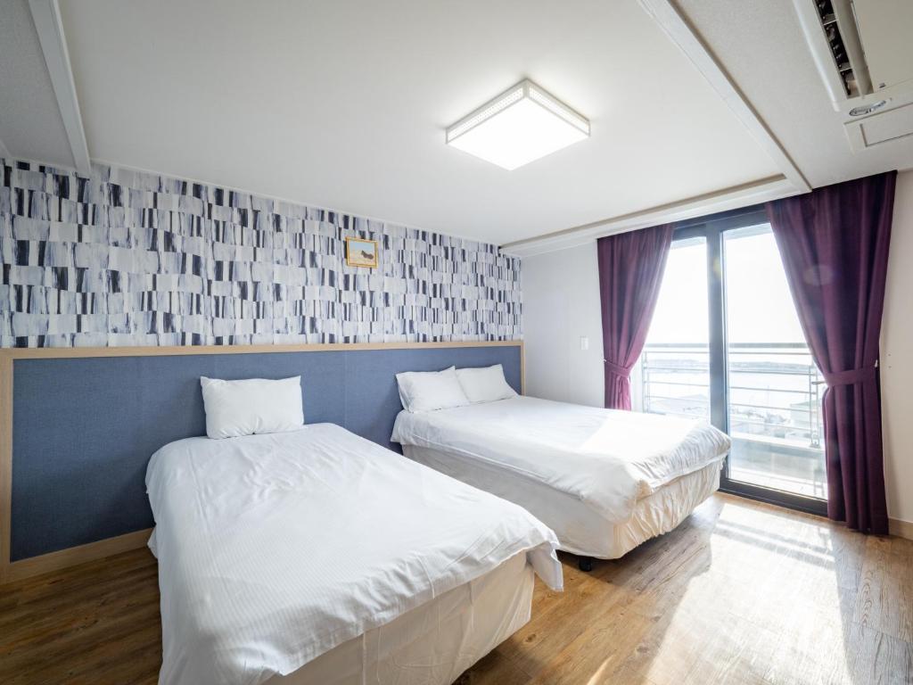 Postel nebo postele na pokoji v ubytování Jeju Moseulpo Hotel