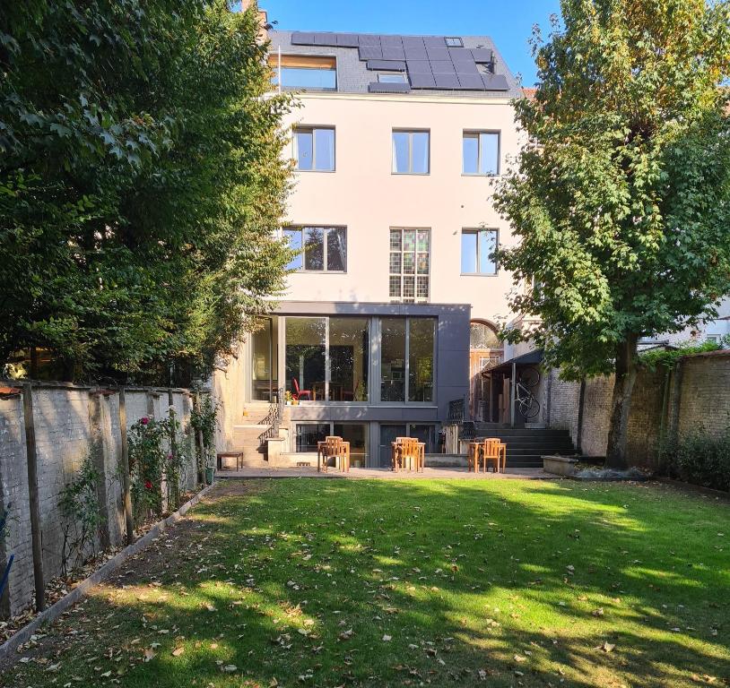 a house with a lawn in front of a building at Maison Willem Tell in Ghent