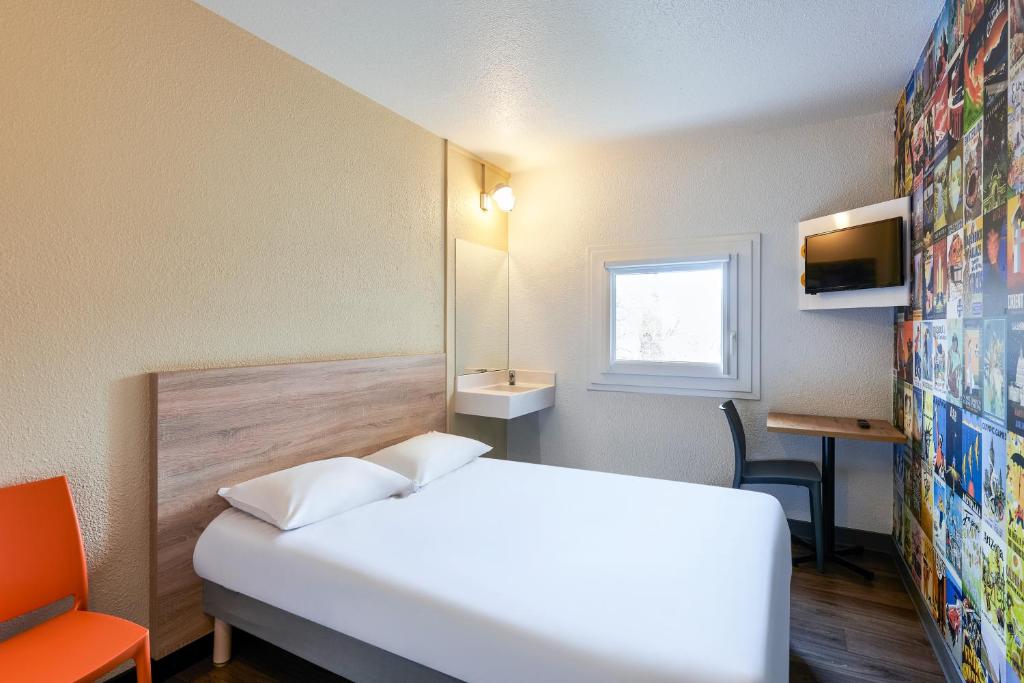 a hotel room with a white bed and a window at hotelF1 Evry A6 in Evry-Courcouronnes