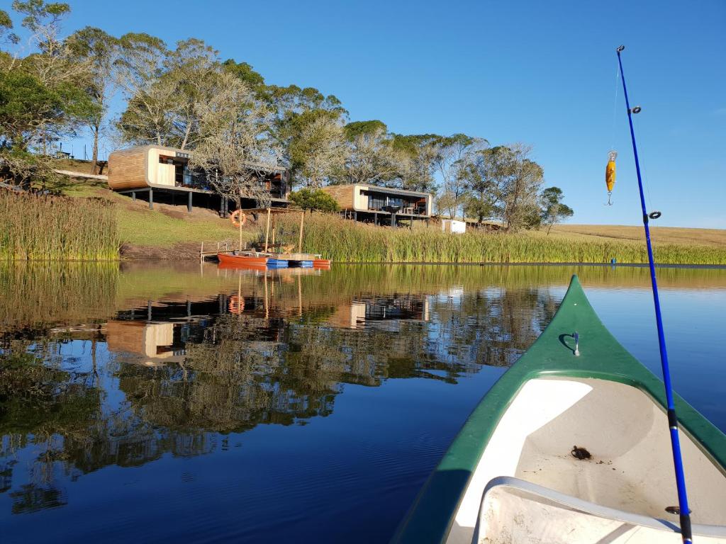 a boat in the water with a fishing pole in it at Buff & Fellow Eco Cabins in George