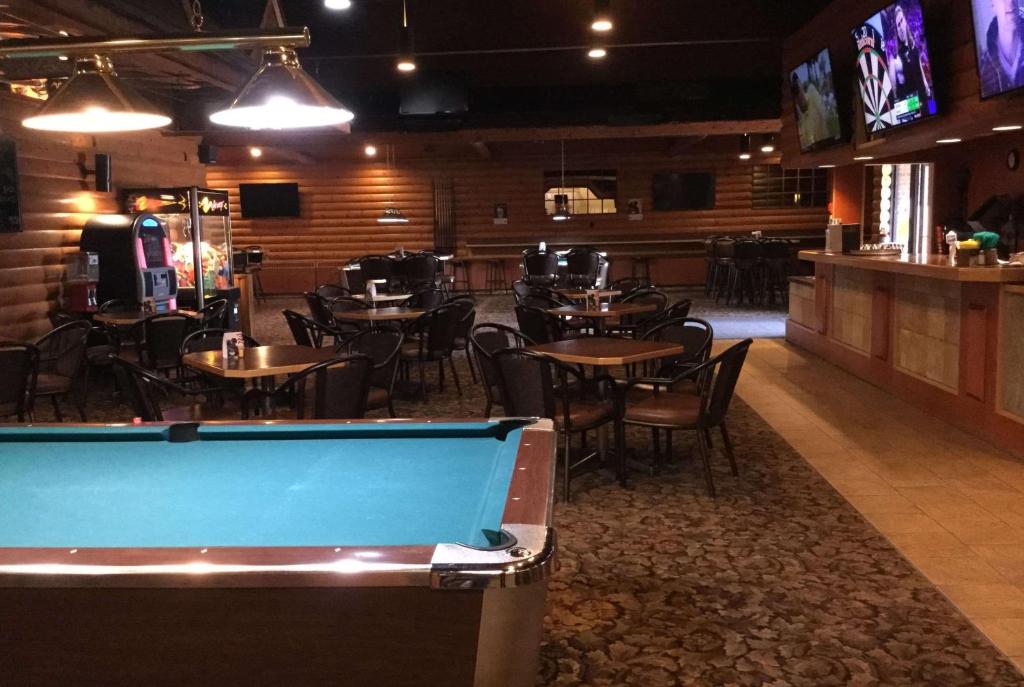 a pool table in a restaurant with tables and chairs at Super 8 by Wyndham Spruce Grove in Spruce Grove
