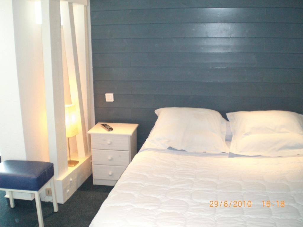 1 dormitorio con cama blanca y pared azul en Le France, en Loudéac