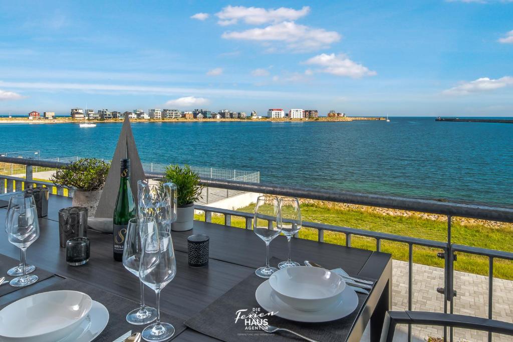 a table with wine glasses and a view of the water at Hafenbrise in Olpenitz