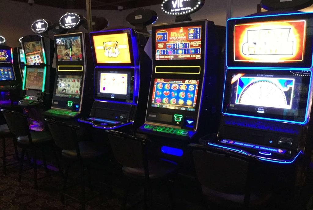 a row of slot machines in a casino at Super 8 by Wyndham Spruce Grove in Spruce Grove