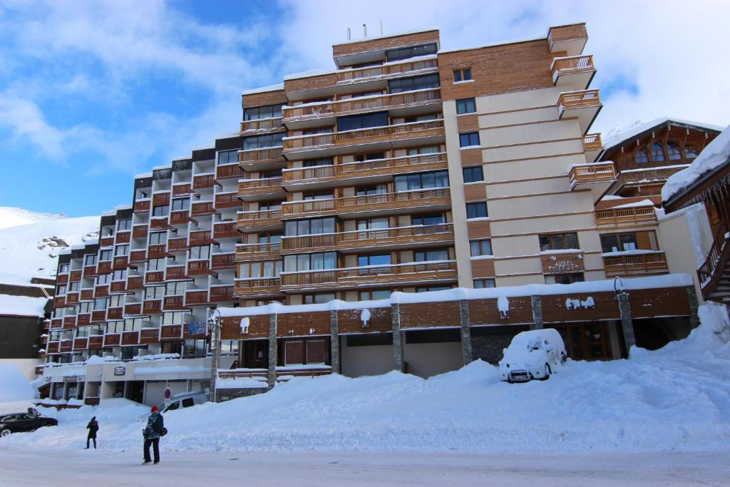 a large building with a pile of snow in front of it at Lac Blanc Appartements VTI in Val Thorens