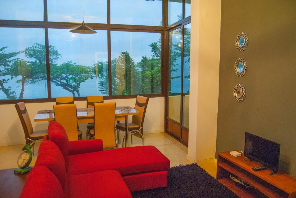 sala de estar con sofá rojo y mesa en Sky Nautico Apartment, en São Tomé