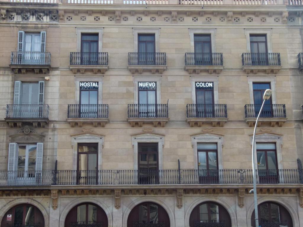 a building with two windows and a clock on the side of it at Hostal Nuevo Colon in Barcelona