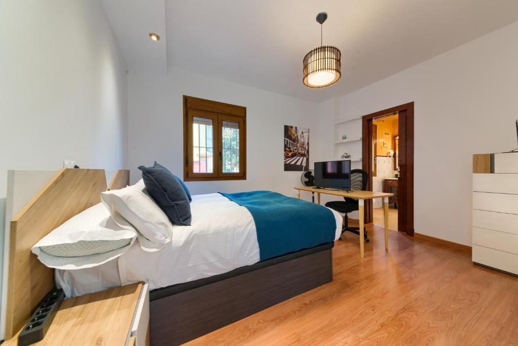 een slaapkamer met een bed en een bureau in een kamer bij Holidays2Malaga Candado House pool & garden in Málaga