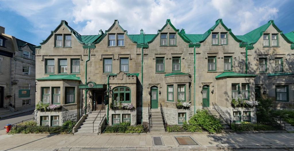 ein großes Steingebäude mit grünem Dach in der Unterkunft Hotel Chateau Bellevue in Québec