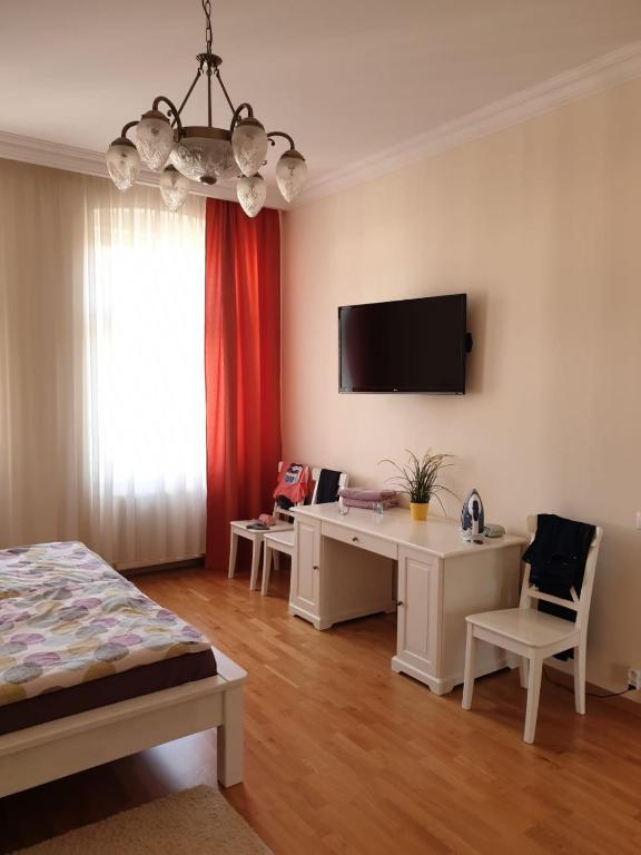 a bedroom with a bed and a desk and a tv at Jurincom apartments Masaryka in Karlovy Vary