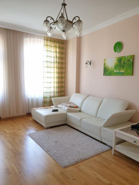 a living room with a white couch and a table at Jurincom apartments Masaryka in Karlovy Vary