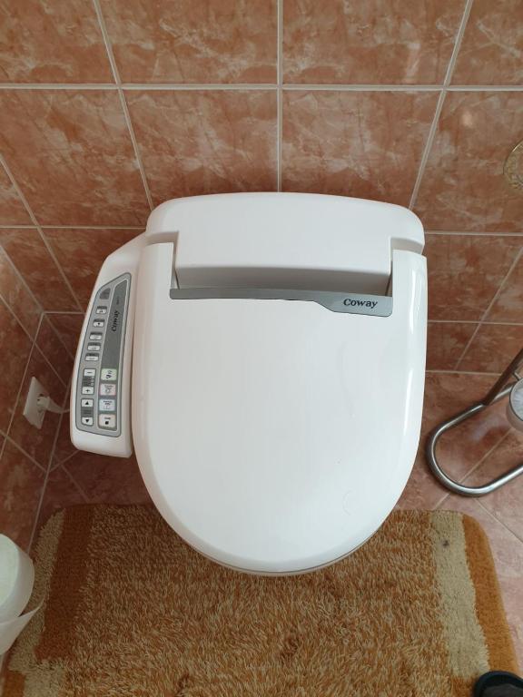 a toilet in a bathroom with a remote control at Jurincom apartments Masaryka in Karlovy Vary