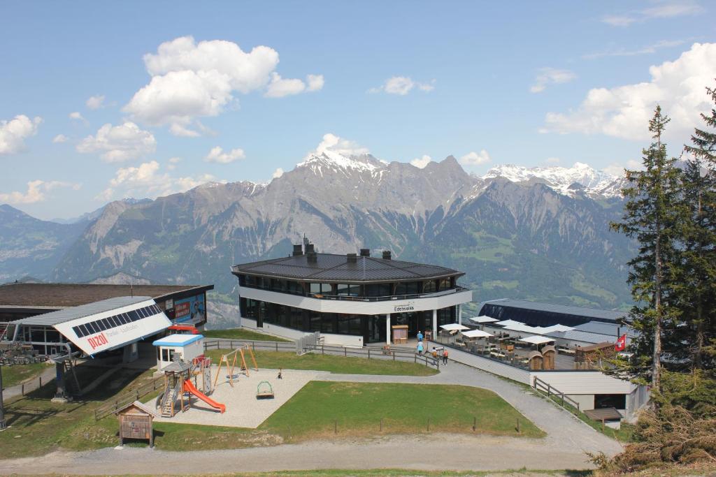 ein großes Gebäude mit Bergen im Hintergrund in der Unterkunft Haus Edelweiss in Bad Ragaz