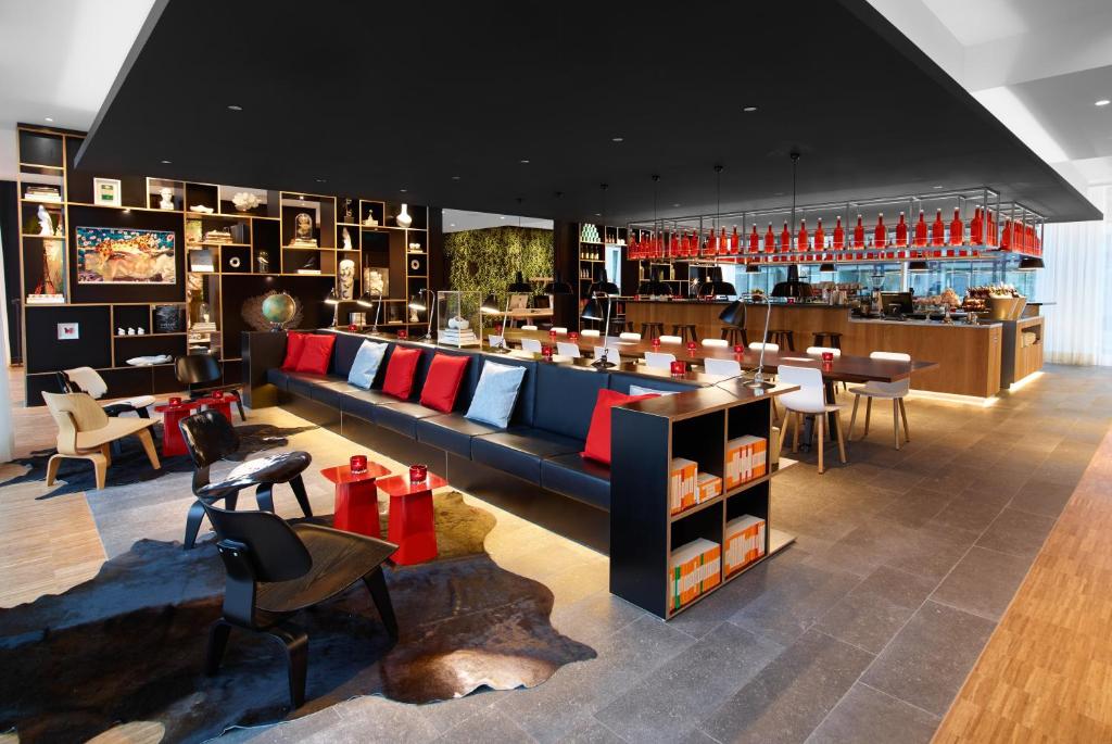 een restaurant met een bar met rood en blauw bij citizenM Rotterdam in Rotterdam