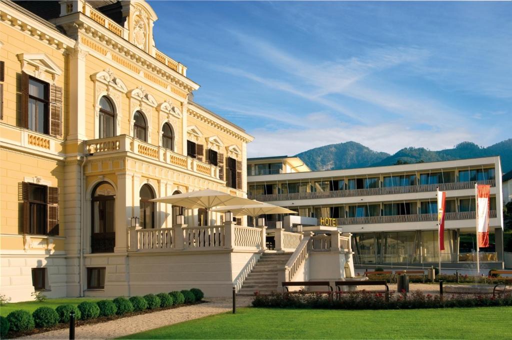 a large white building with a table in front of it at Villa Seilern Vital Resort in Bad Ischl