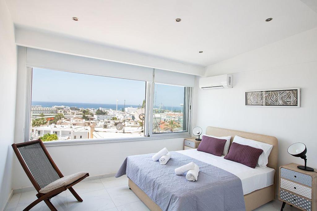 a bedroom with a bed and a large window at Apt Misia Enas - Modern 2 Bedroom Apartment with Sea Views - Close to Ayia Napa Square in Ayia Napa