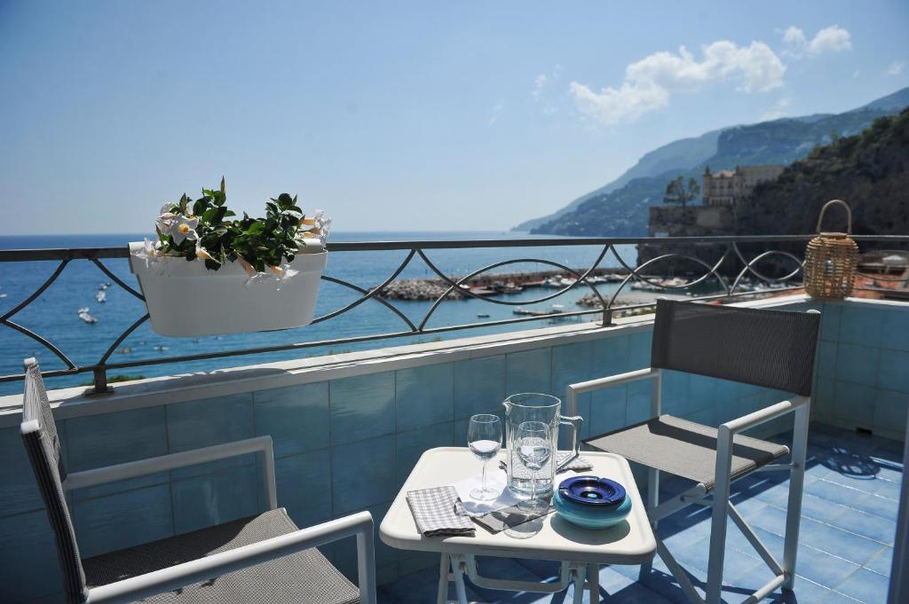 a table and chairs on a balcony with a view of the water at Residence Panoramic in Maiori