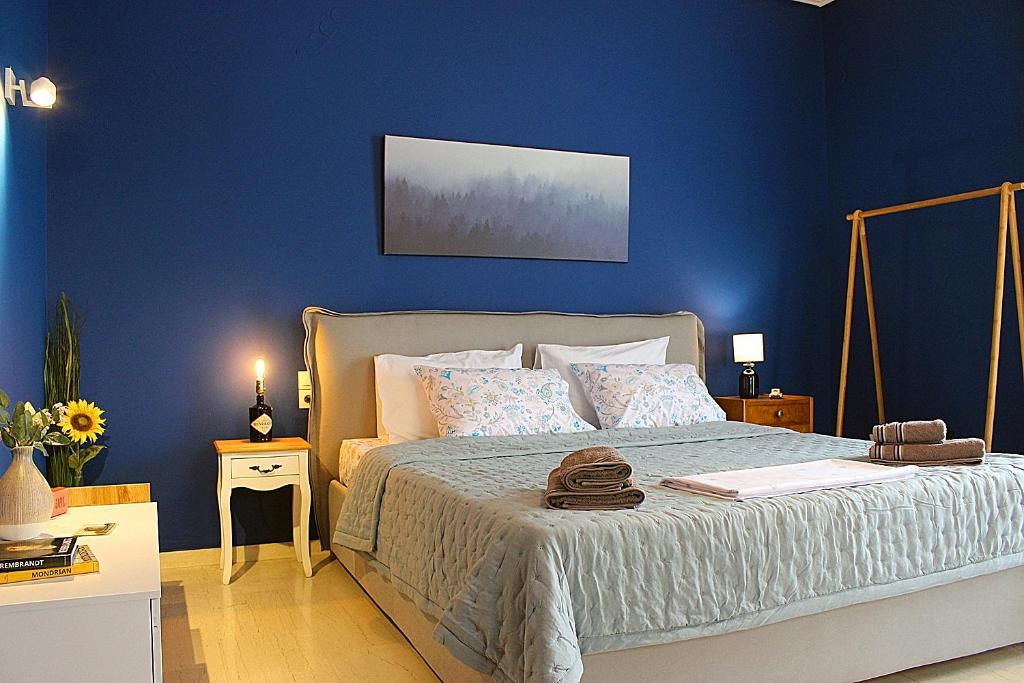 a bedroom with a bed with a blue wall at Homel Rocks -Elegant Apt 2BD -Amazing garden view in Kalabaka