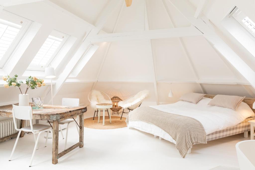 ein Schlafzimmer mit einem Bett, einem Tisch und Stühlen in der Unterkunft Luttik in Alkmaar
