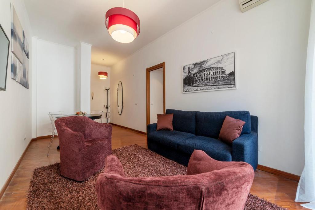 ein Wohnzimmer mit einem blauen Sofa und 2 Stühlen in der Unterkunft Metro Cipro! Alle spalle del Vaticano Apartment x4 in Rom