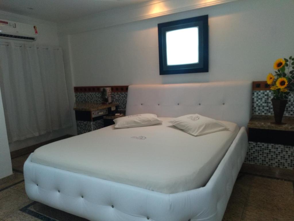 uma grande cama branca num quarto com uma janela em Hotel Itaoka (Adults Only) no Rio de Janeiro