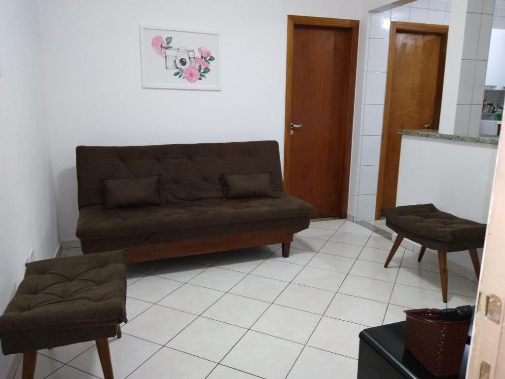 ein Wohnzimmer mit einem Sofa und 2 Stühlen in der Unterkunft Apto no Bairro do Gonzaga in Santos