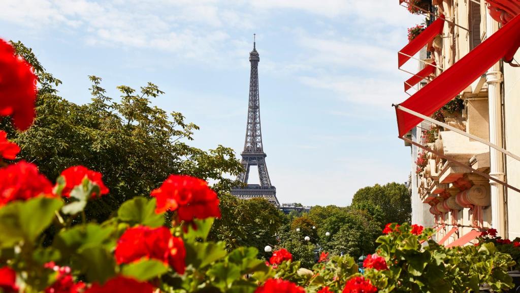 uma vista para a torre Eiffel com flores vermelhas em Hôtel Plaza Athénée - Dorchester Collection em Paris