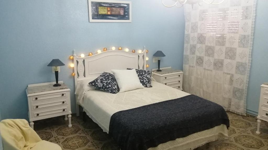 una camera con un letto con due comodini e due lampade di Ca la Glori a Los Corrales