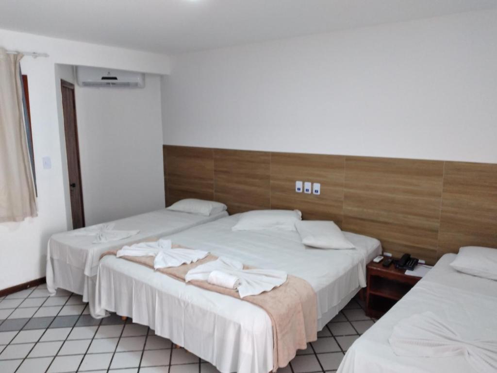 Habitación de hotel con 2 camas y toallas. en Arraial do Sol Beach Hotel, en Arraial d'Ajuda