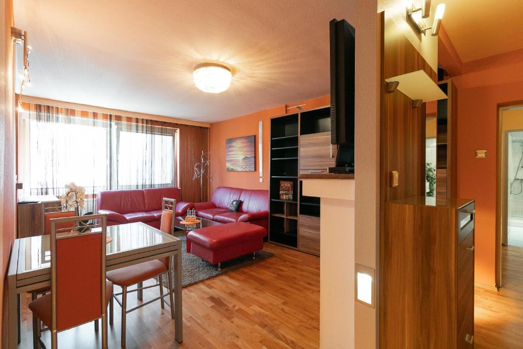 - un salon avec un canapé rouge et une table dans l'établissement Zentrales Apartment in U-Bahn Nähe & Hauptbahnhof, à Vienne