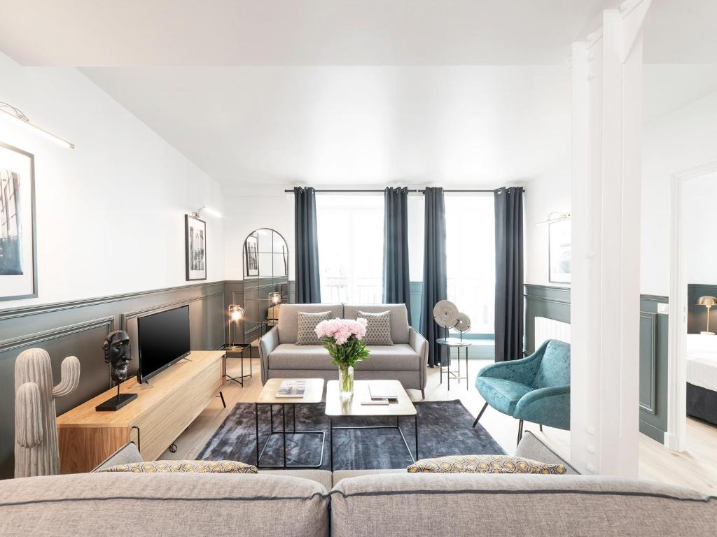 un salon avec un canapé et une table dans l'établissement LivinParis - Luxury 4 Bedrooms Le Marais I, à Paris