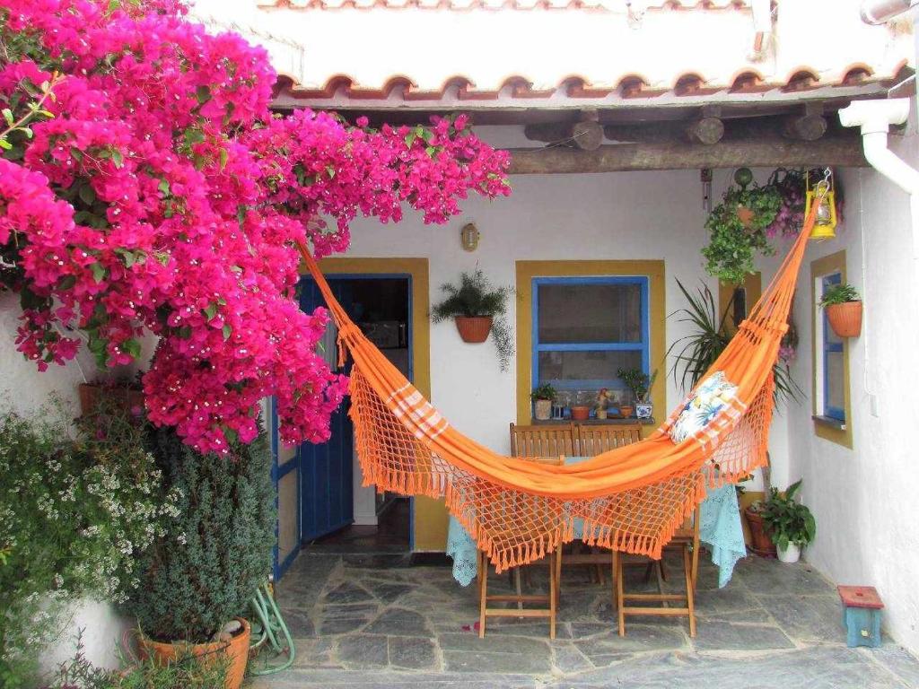 an orange hammock on a patio with pink flowers at Casa Montoit8 in Montoito