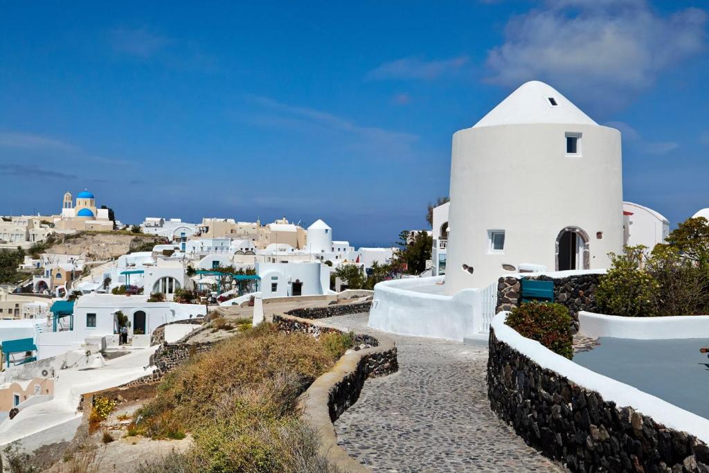 widok na wioskę z białym budynkiem w obiekcie Windmill Maisonette Asv Oia Santorini w mieście Thólos