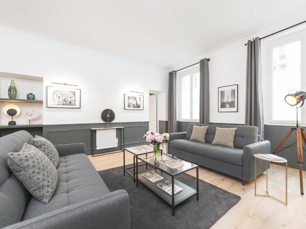 een woonkamer met 2 banken en een tafel bij LivinParis - Luxury 3 Bedrooms Opera I in Parijs