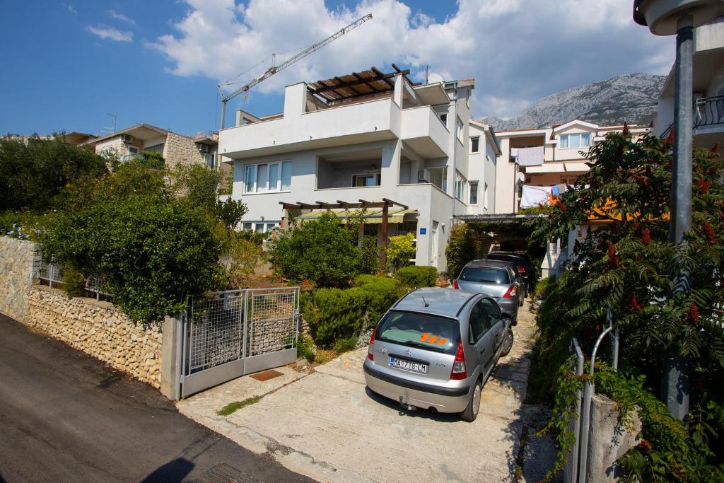 a car parked in a parking lot in front of a house at Apartmani Slobodan in Makarska