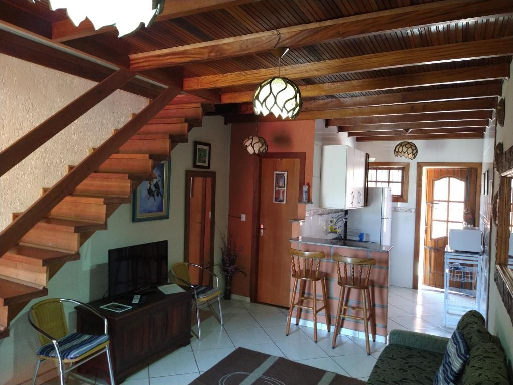a kitchen and living room with a wooden ceiling at Chale da Ana in Santo Antônio do Pinhal