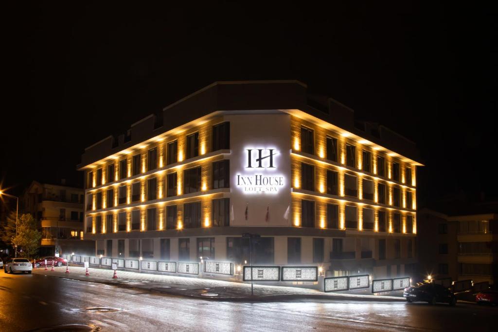 un edificio iluminado en una calle por la noche en INN HOUSE LOFT SPA, en Çankaya