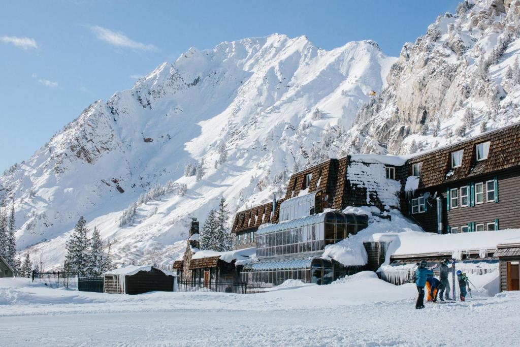 a building in the snow with a mountain in the background at Alta Peruvian Lodge in Alta