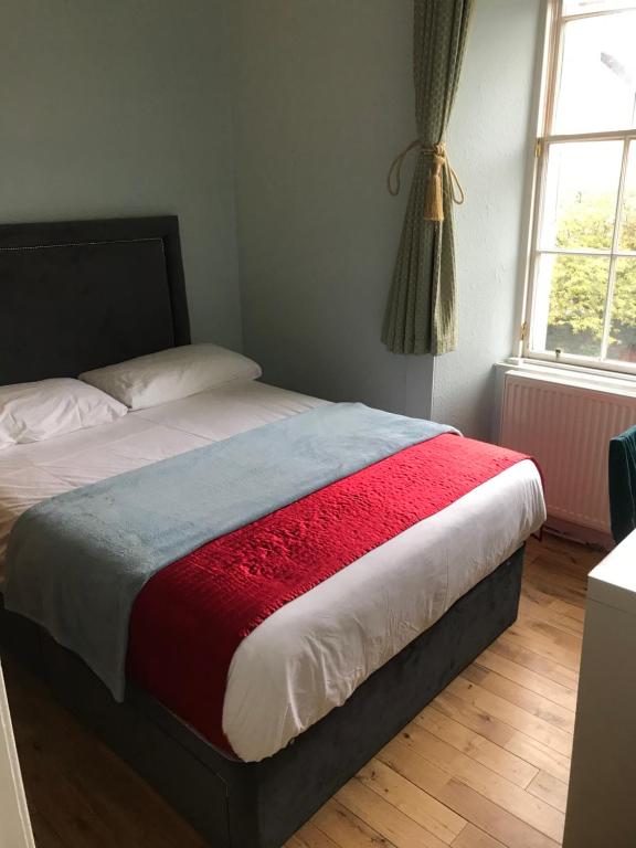 エディンバラにあるEdinburgh City Holiday Apartmentsのベッドルーム1室(ベッド1台、赤と白の毛布付)